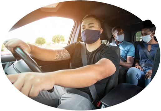 With two masked passengers in the back, a masked rideshare driver checks directions.